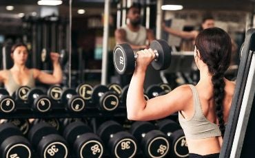 female performing dumbbell shoulder press